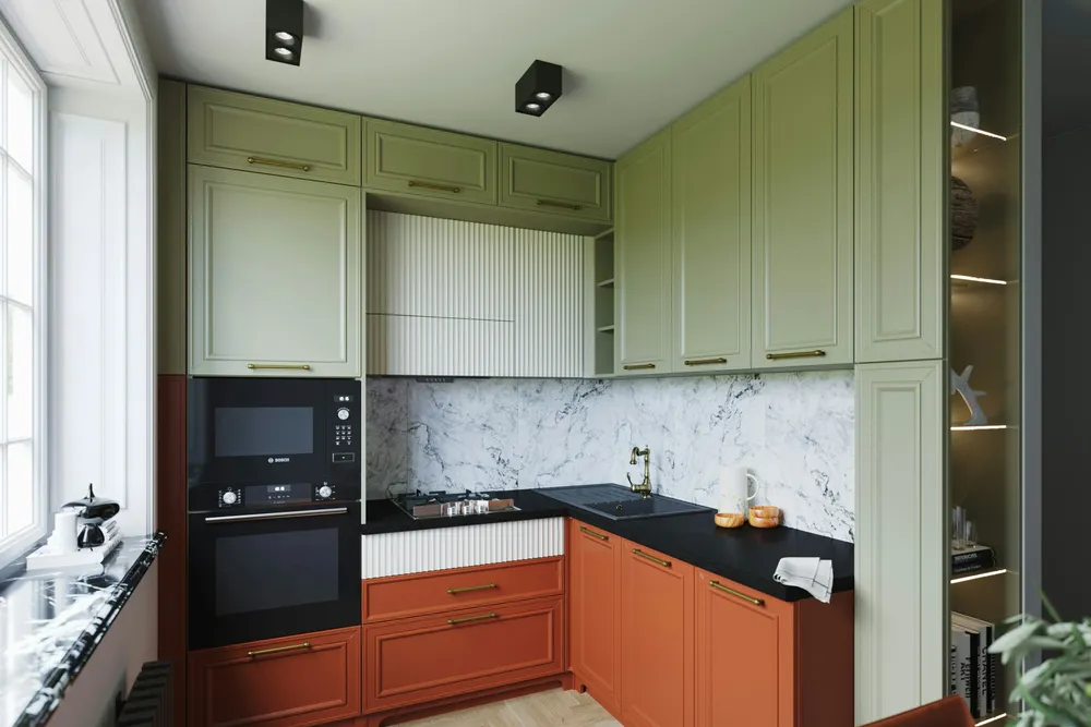 Hoekkeuken met saliegroene bovenkasten tot het plafond, terracotta onderkasten, een zwart werkblad, een marmerlook achterwand en een raam links